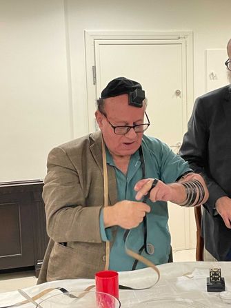 Simentov perked up when Rabbi Chitrik invited him to put on tefillin (Photo by David Ian Klein)