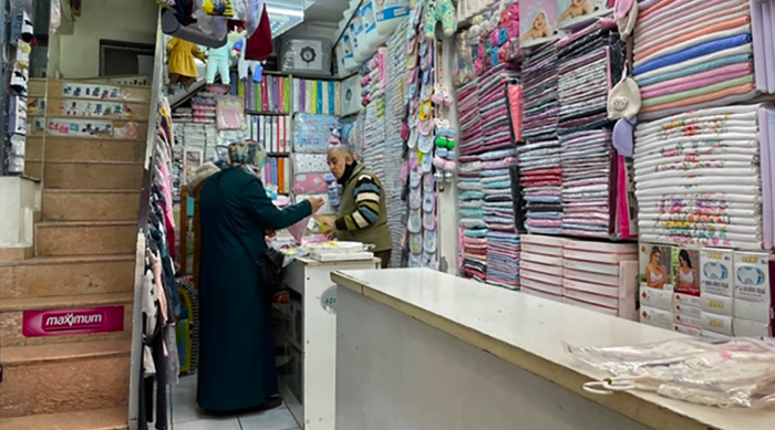 Daoud Cemel speaks with a customer in a shop in Antakya’s famed Long Bazaar. (David I. Klein)